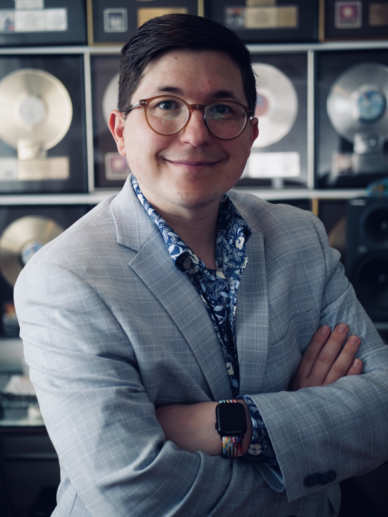 Stephen T. Cox smiling in front of framed records